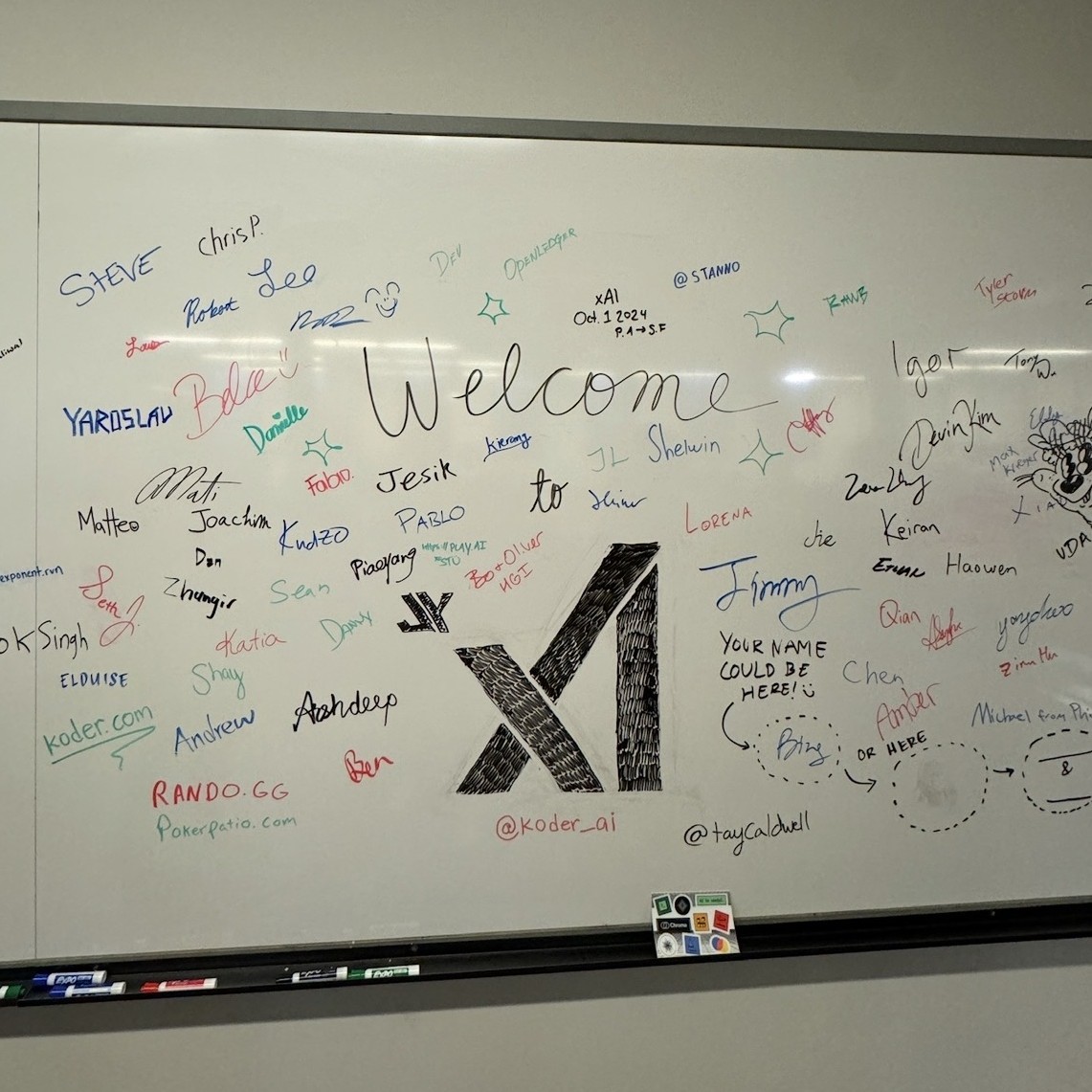 Whiteboard reading Welcome to xAI, Oct 1 2024, with founding team signatures